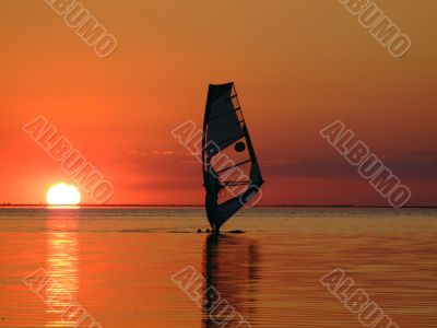 Silhouette of a windsurfer on waves on a sunset 2