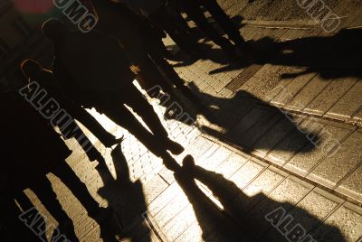 Shadows of people walking on the city street