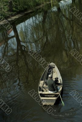 Man and dog  in boat on river