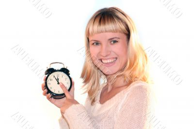 Young blond woman show time on alarm clock. The shot like concept of eve xmas or end of sales