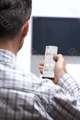man in front of tv switching channel