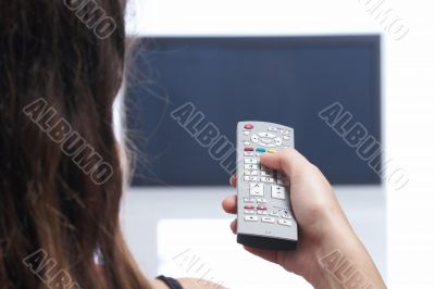 Woman with remote control in front of TV