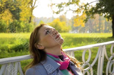 The red-haired woman has a rest in park The red-haired woman has a rest in park