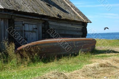 An old shed with a reverse fishing boat on the lake bank