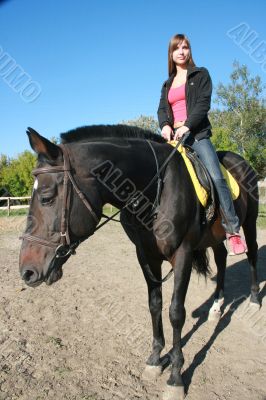 female equestrian in saddle of black stallion