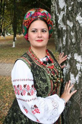 Woman in Ukrainian costume near birch