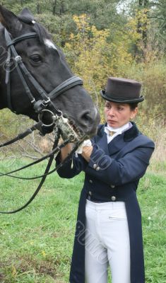 equestrian female holds black stallion