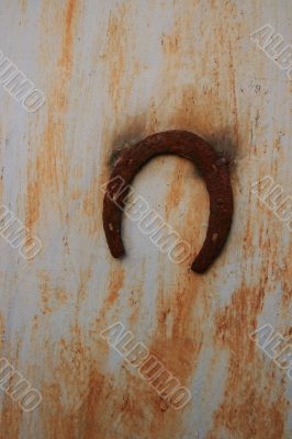 Rusty horseshoe on rusty wall