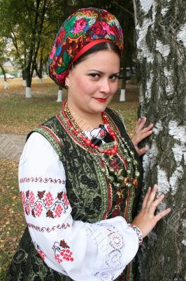 Young lady in Ukrainian costume near birch