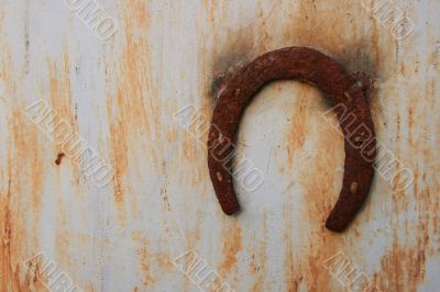 Rusty horseshoe on rusty wall