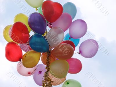 Set of colorful rubber balloons flies in blue sky
