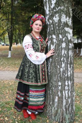 Young lady in Ukrainian costume near birch