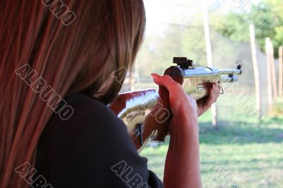 backside wiev of female shooter taking aim