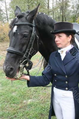 equestrian spotswoman holds black stallion