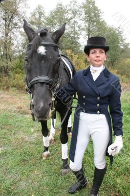 equestrian spotswoman holds black stallion