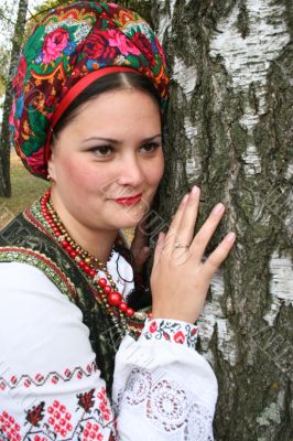 Young lady in Ukrainian costume near birch