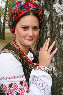 Young lady in Ukrainian costume near birch
