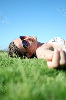 The young beautiful girl lays on a grass