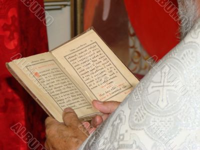 Opened Slavic Gospel in hands of orthodox priest