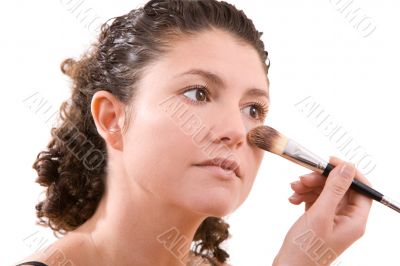 Beautiful brunette applying foundation