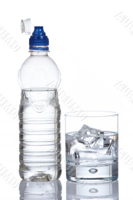 Bottle and glass of mineral water with droplets