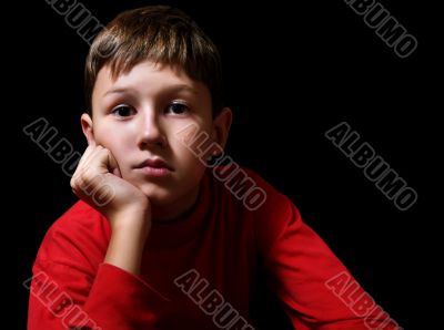 The thoughtful boy in a dark room