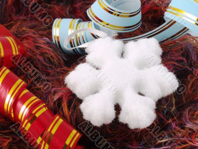 Christmas snowflake and ribbons on fluffy background