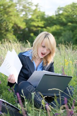 Happiness woman on grass with laptop and documents