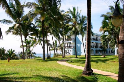 Tropical seaside resort hotel building with palm trees