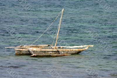 A small wooden boat anchored in the bay