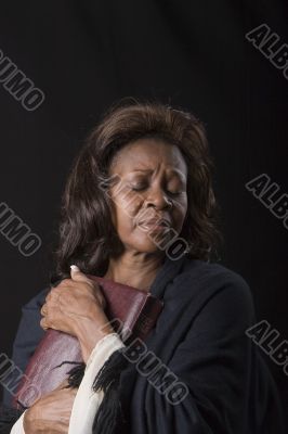 Woman Clutching Bible Eyes Closed