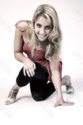 Studio portrait of a long blond girl on one knee