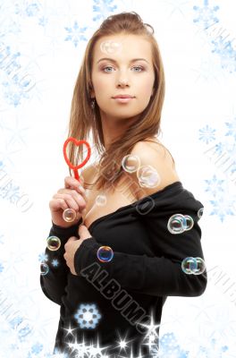 girl with heart-shaped blower and snowflakes