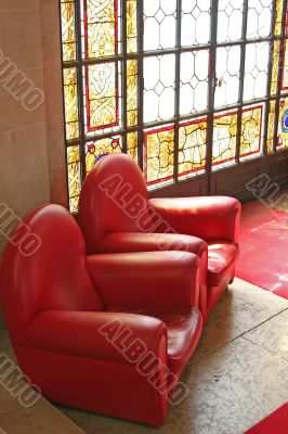 Sofas in waiting area with stained glass window