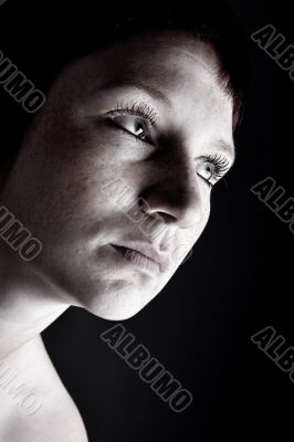 Studio portrait of a young woman with short hair in the dark