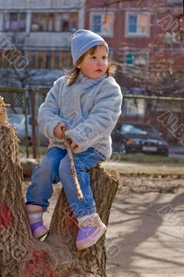 Kid sitting on stump