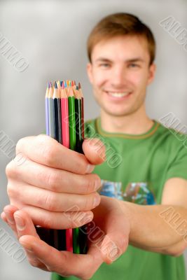 multi-coloured pencils in hands multi-coloured pencils in hands