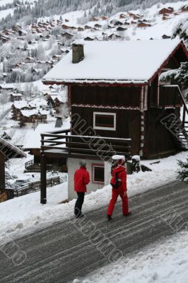 Walkers passing alpine chalet