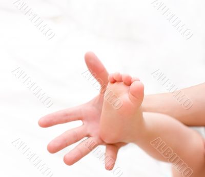 Man hold baby leg on palm