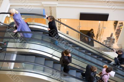 Peoples on escalators in a mall. Motion blur
