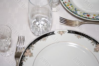 Close-up of served table with wineglass and plates
