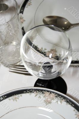 Close-up of served table with wineglass and plates
