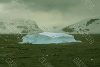 Iceberg glowing in an overcast dawn