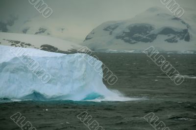 Iceberg glowing in an overcast dawn