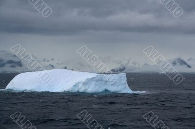 Iceberg glowing in an overcast dawn