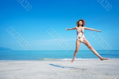 woman jumping happily in swimsuit