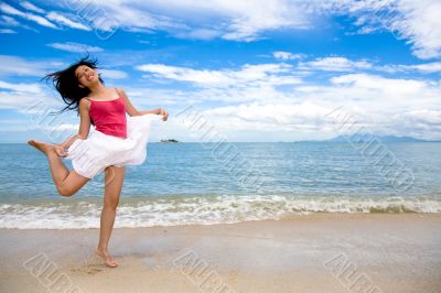 young woman jumping playfully at the beach young woman jumping playfully at the beach