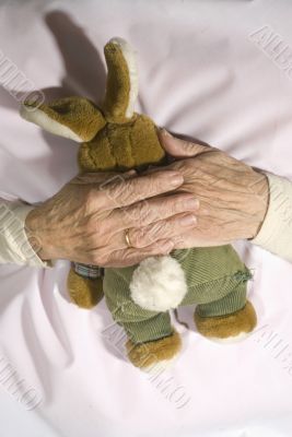 Old demented person with stuffed rabbit