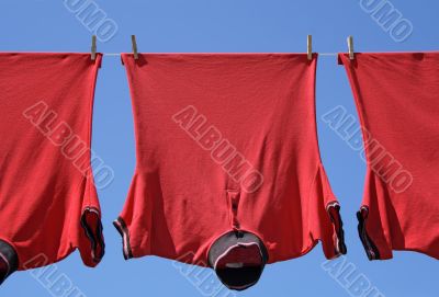 Laundry closeup, three red t-shirts