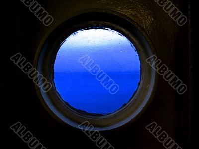 Blue sea and sky through rainy porthole